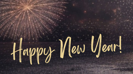 Happy New Year hand lettering against fireworks exploding in the night skyの素材