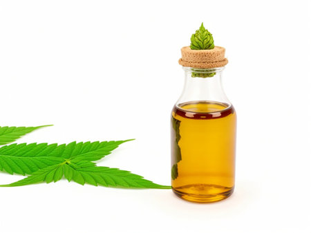 Cannabis oil in a glass bottle with leaves isolated on white backgroundの素材