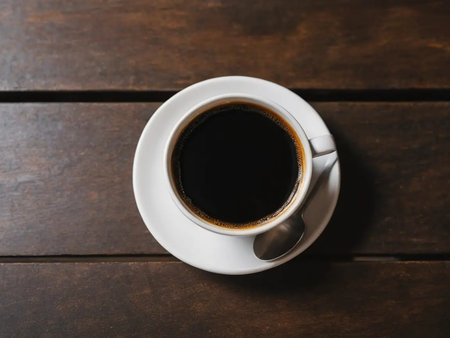 Cup of coffee on wooden table, top view. Space for text
