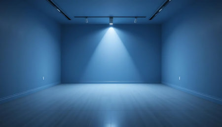 A photograph of an empty blue room with spotlight lighting in the center.の写真素材