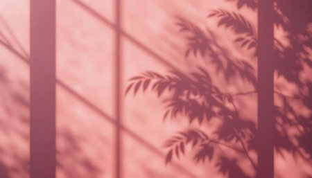 Shadow of leaves on a pink wall background. Copy space for text.の写真素材
