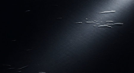 An abstract of scattered water droplets on a dark textured surface