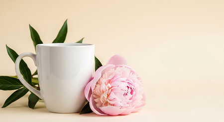 A delicate pink peony blossom and green leaves adorn a pristine white mug against a soft, neutral backdrop, conveying a sense of tranquility and refined elegance.の写真素材
