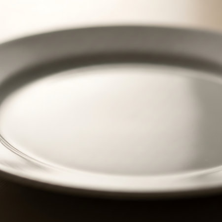 Empty plate on a black background. Shallow depth of field.の写真素材