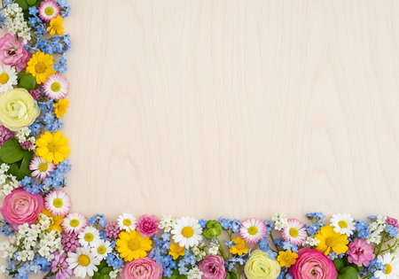 Frame made of flowers on a wooden background with space for text.の写真素材