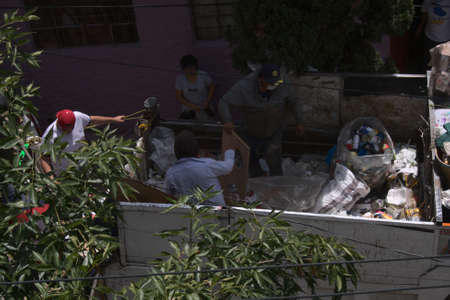 Mexico City, Mexico ; 07 18 2020: Garbage can and dustman, collecting people's wasteのeditorial素材