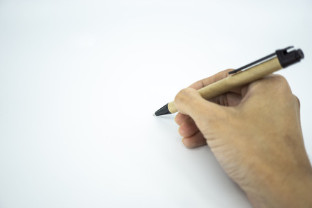 Hand holding ballpoint pen pointing on white paper. Selective focus.の写真素材