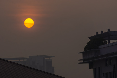 Yellow orange color sun rise behind the building.の写真素材