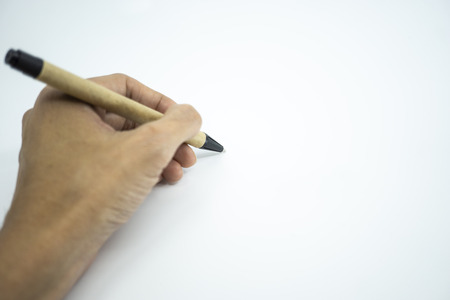 Hand holding ballpoint pen pointing on white paper. Selective focus.の写真素材