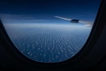 View from airplane window with blue sky and cloudsの写真素材