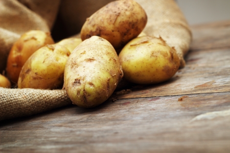 Raw potatoes on wooden backgroundの写真素材
