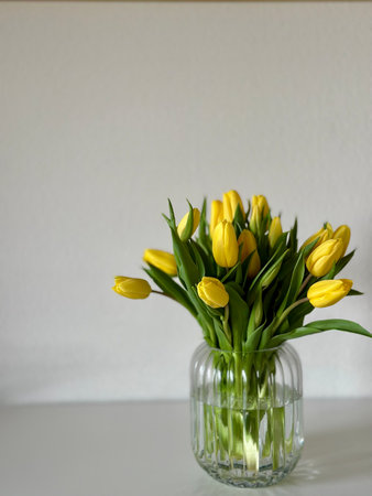 Bouquet of yellow tulips in a vase on the tableの写真素材