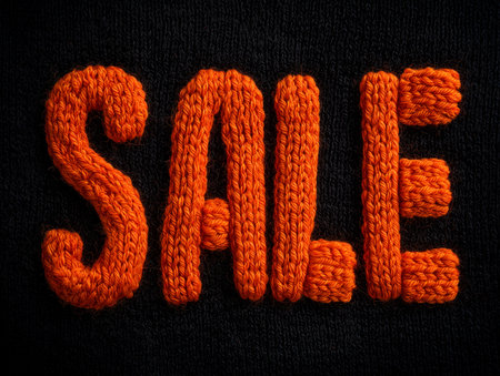 Word sale written with a knitted texture of orange thread. Sale concept.の素材