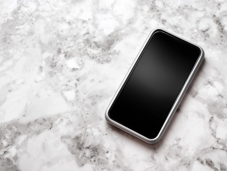 Smartphone with black screen on white marble background. Top view.の素材
