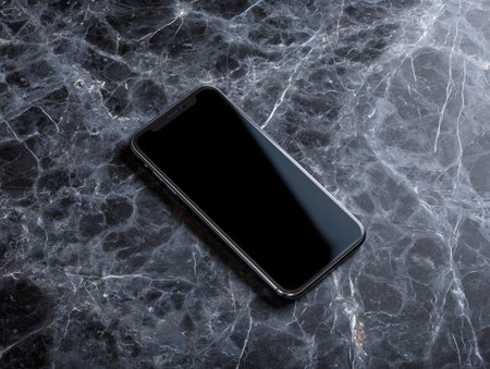 Smartphone with blank screen on marble black table. Mockup for design.の素材