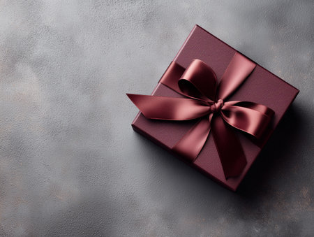 Gift box with bow on stone background. Top view with copy spaceの素材