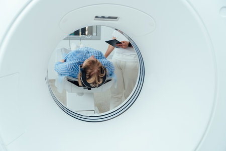 Unrecognizable doctor preparing female patient for MRI scan. Woman enters into MRI capsule.の写真素材