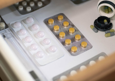 White medical pills in the wooden household drawer shelf at home from office table closeup. Tablet drugs virus. Cure at home by yourself, self-isolation recovery Description (in English) 162の写真素材