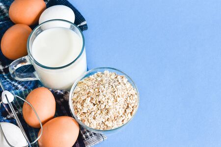 Milk, eggs and oatmeal on a blue background. concept of healthy eating, dieting.の写真素材