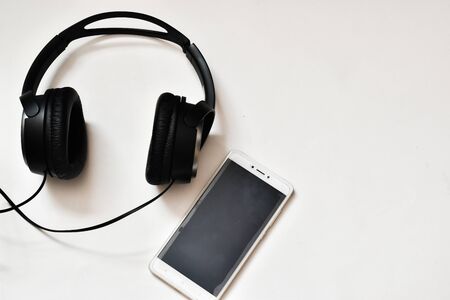 Headphones and mobile phone on a white background. IT technology concept.の写真素材