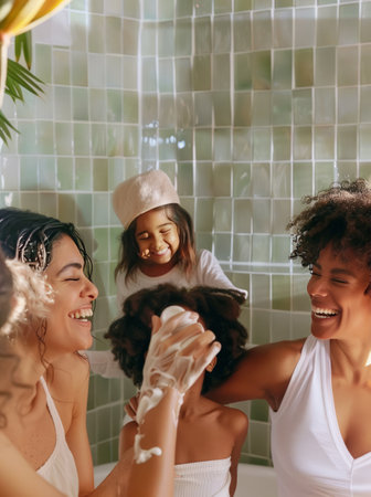 Group of happy young multiethnic women having fun in the bathroom and washing their hairの素材