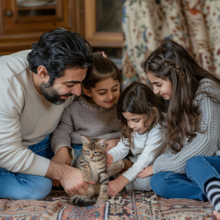 Happy family with two daughters and a cat sitting on the floor at homeの素材