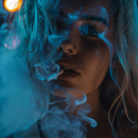 Portrait of a beautiful girl with blue smoke in her mouth.の素材
