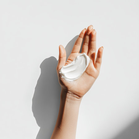 Female hand with moisturizing cream on a white background, top viewの素材