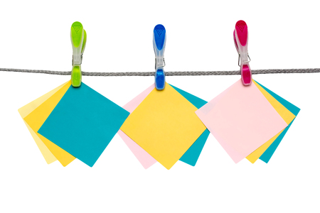 Multicolored clothespins with blank paper.の写真素材