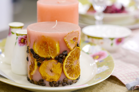 Decorative aroma candle with fruit and coffee on a festive table.の写真素材
