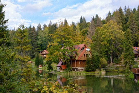 House near the lake in the forest, autumn day.の写真素材