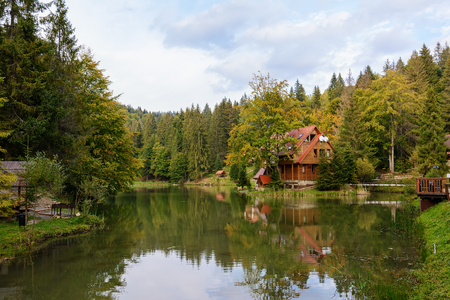 House near the lake in the forest, autumn day.の写真素材