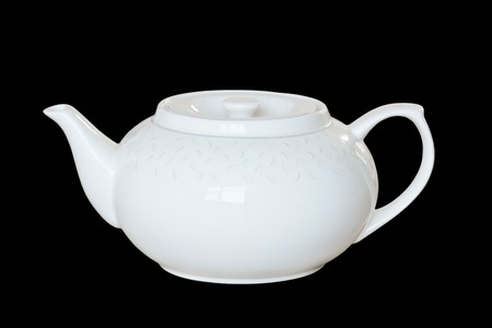 White porcelain teapot to brew tea or fragrant, healing herbs. Isolated, black 

background.の写真素材
