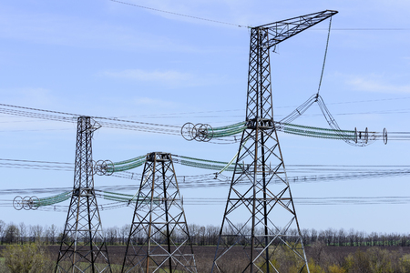 High-voltage power lines against the blue sky.の写真素材