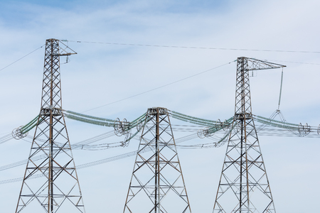 High-voltage power lines against the blue sky.の写真素材