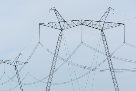 High-voltage power lines against the blue sky.の写真素材
