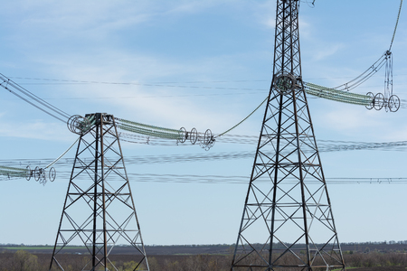 High-voltage power lines against the blue sky.の写真素材