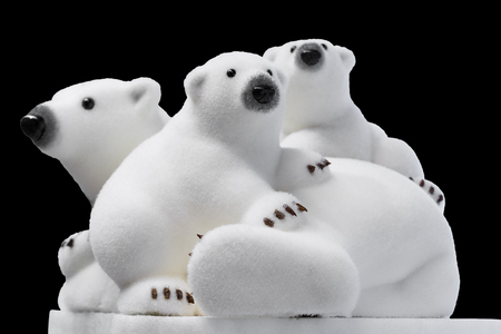Christmas and New Year decorations: Figurines of a white polar bears with cubs. Isolated on a black background.の写真素材
