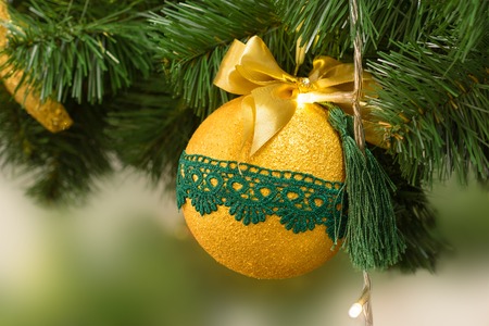 Christmas and New Year golden ball on the Christmas tree. New Year's toy.の写真素材