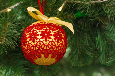 Christmas and New Year golden ball with lace red pattern on the Christmas tree. New Year's decoration.の写真素材