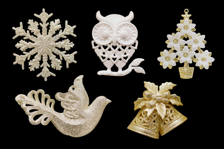 Christmas and New Year decorations: figurines of a snowflake, owl, flowering tree, dove, 

bells. Isolated, black background.の写真素材