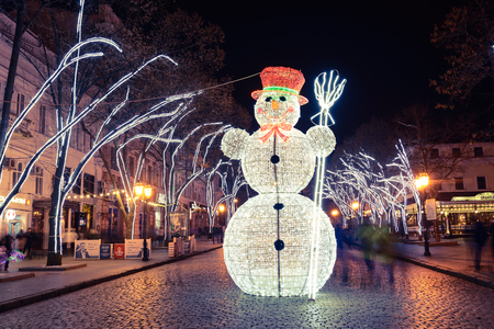 Odesa, Ukraine  - January, 7, 2018: Christmas and New Year decor in Odesa on Deribasovskaya street. Tree with garland of glowing lights and big glowing snowman in night city.のeditorial素材