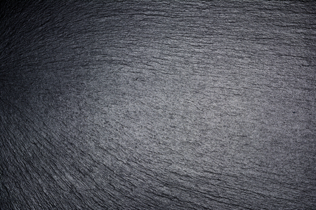 Board, plate or tray of black slate. Dark textured background.の写真素材