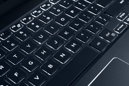 Black backlit computer keyboard, laptop keypad. Panel of keys that operate a computer.