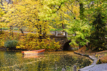 Ancient stone bridge in the autumn National Dendrology Park of Sofiyivka, Uman, Ukraine. Pleasure boat on the water.の写真素材