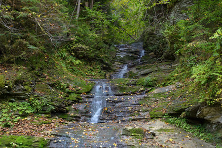 Waterfall Seredniy Huk, Bukovynski cascades in Velykyi Roztoky in the autumn forest. Carpathian...