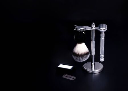 Razor, brush, and blade against a black backgroundの写真素材