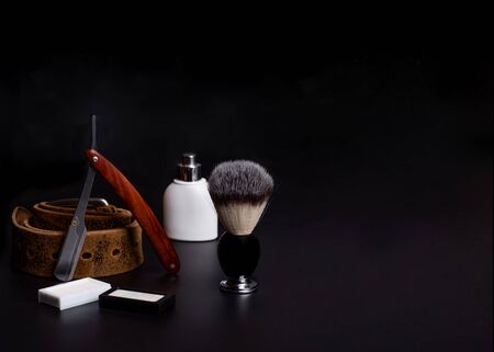 Razor, brush, and perfume on a black background.の写真素材