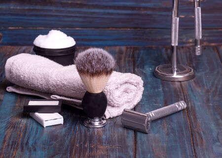 Different razors, blades, brush, perfume and towel on a wooden backgroundの写真素材