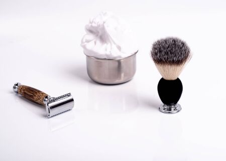 Razor, brush, and shaving foam on a white background.の写真素材